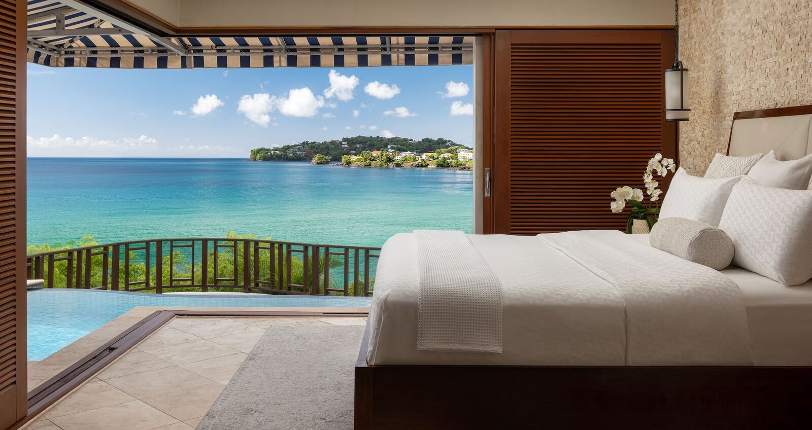 Ocean-view suite bedroom opening onto a private pool at a Sandals resort