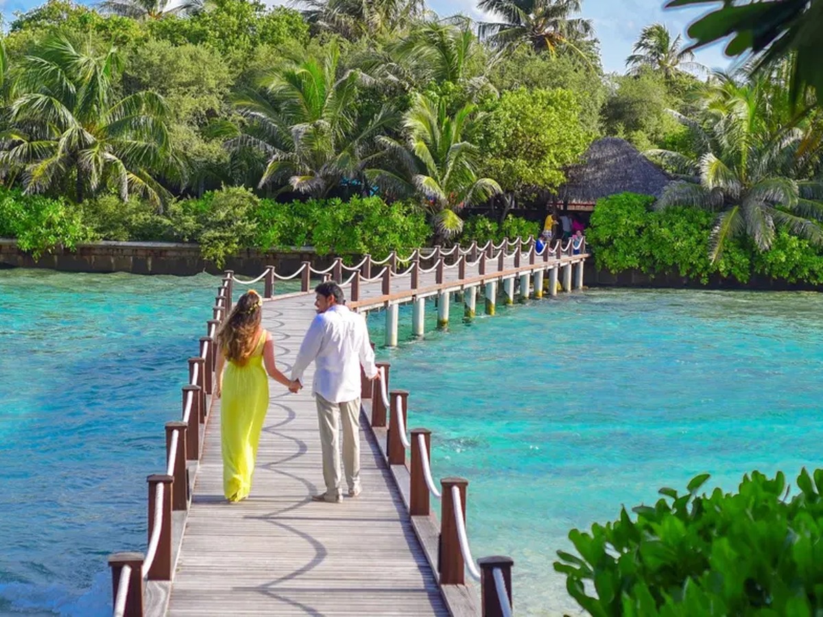 Couple on a walkway over a turquoise lagoon