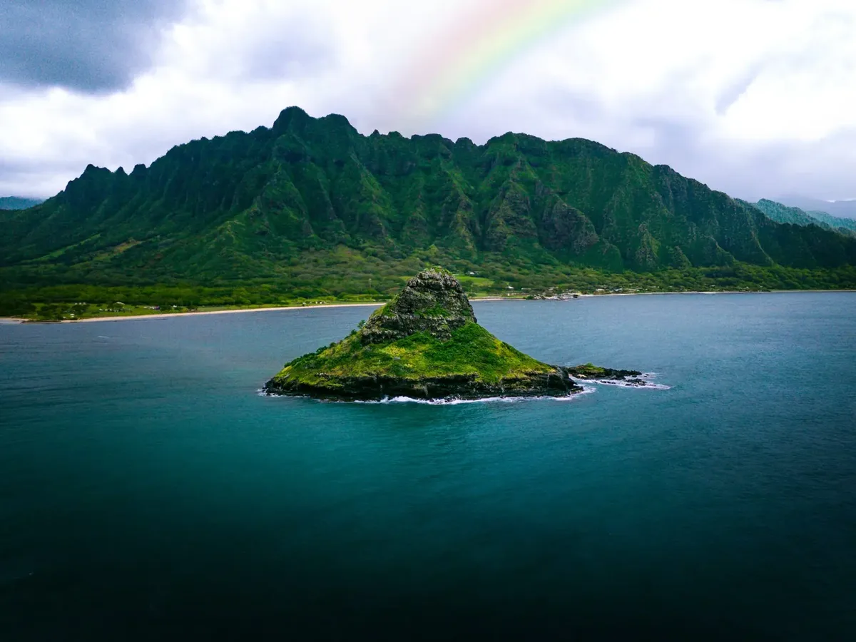 Rainbow over the Kualoa mountains and Mokolii Island on Oahu's windward coast